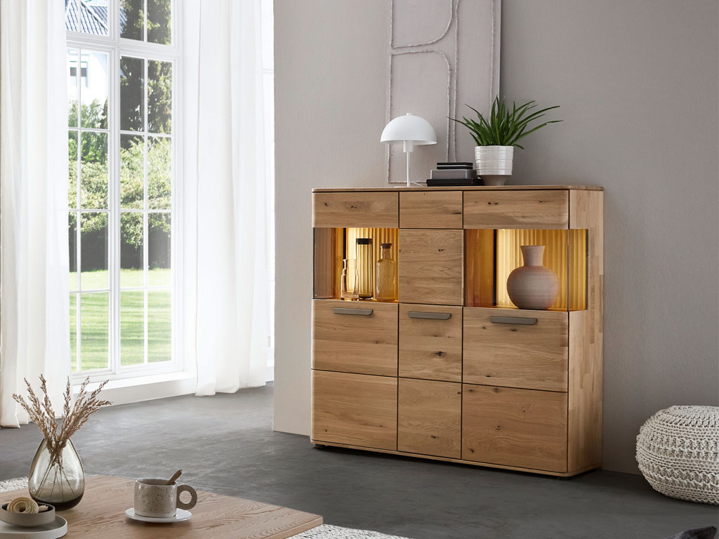 modernes Highboard aus Holz mit zwei Vitrinenausschnitten beleuchtet stilvoll dekoriert in einem modernen zimmer