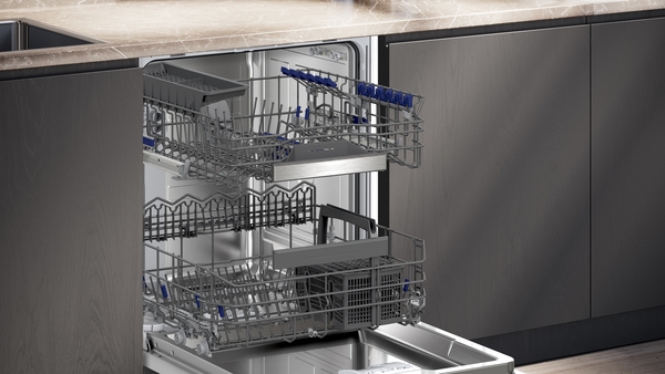Detailansicht des geöffneten Geschirrspülers, die die flexiblen, höhenverstellbaren Körbe zur optimalen Beladung zeigt.
