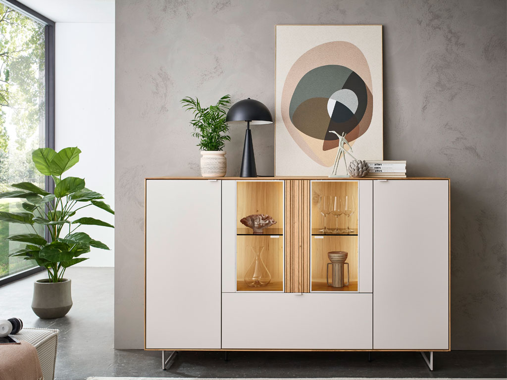 modernes Highboard mit Vitrinenausschnitt und Beleuchtung in braun-weiß stilvoll dekoriert in einem hellen Raum