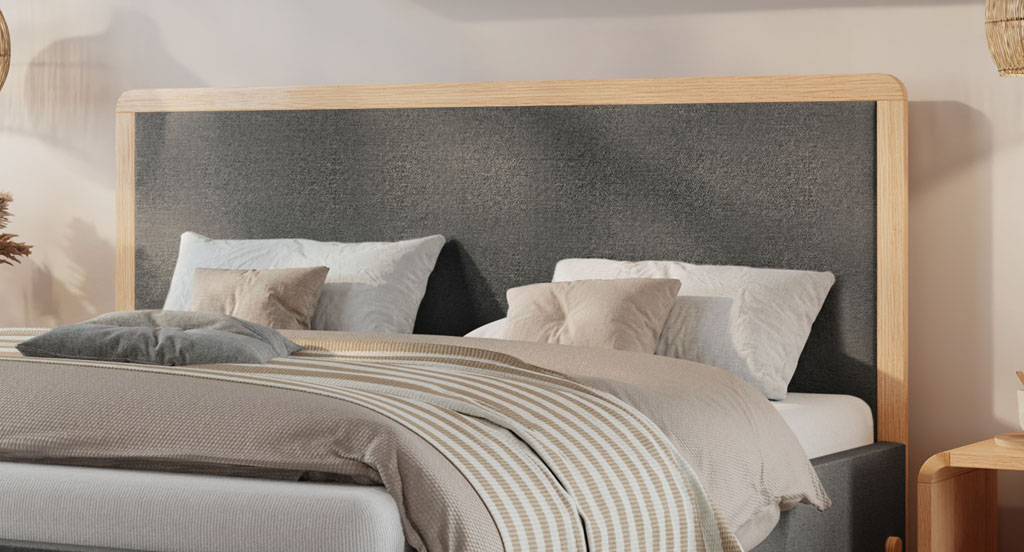 Nahaufnahme des dunkelgrauen Kopfteils mit massivem Eichenholzrahmen an einem modernen Polsterbett (KI-generiert)