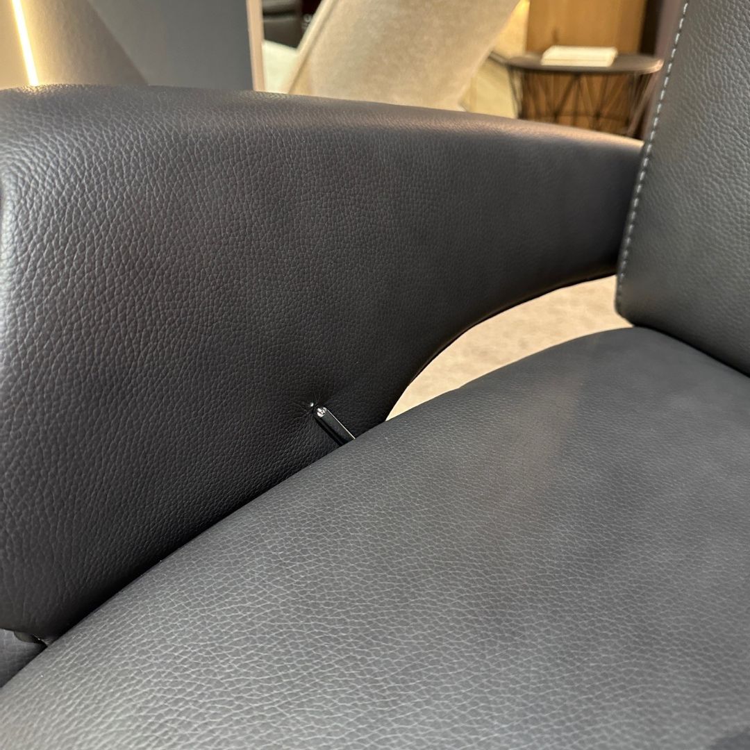 Nahaufnahme eines grauen Ledersessels mit präzisen Nähten und elegantem Design