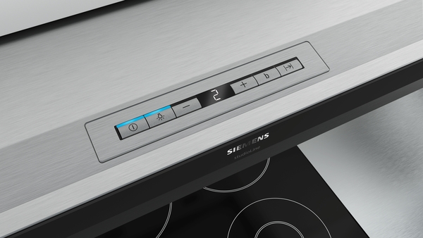 Nahaufnahme einer Siemens Dunstabzugshaube aus Edelstahl mit integriertem Touch-Bedienfeld über einem modernen Kochfeld.