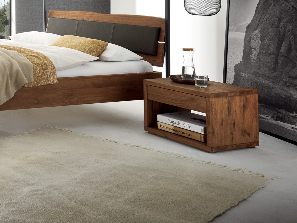 brauner Holznachtschrank mit offenem Fach unten und einer Schublade stilvoll dekoriert an einem holzbett in einem modernen hellen zimmer Cubo von Hasena