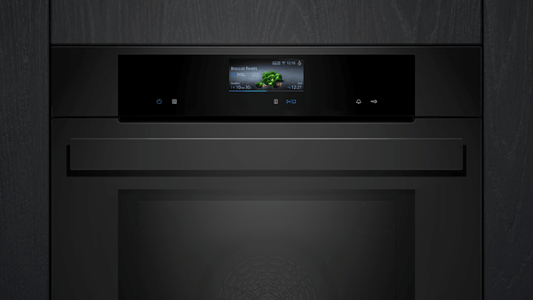 Frontale Studioaufnahme des Siemens studioLine Backofens in tiefschwarzem Glasdesign mit markantem Griff und zentralem Farbdisplay.