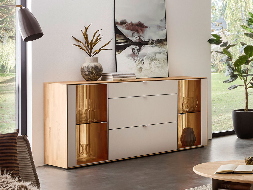 modernes Sideboard mit zwei Vitrinenausschnitten und Beleuchtung in braun-weiß stilvoll dekoriert in einem hellen Raum