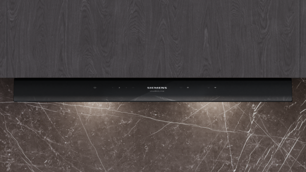 Frontansicht des eleganten schwarzen Bedienfelds der Siemens studioLine mit beleuchtetem Logo und Touch-Symbolen für Licht und Leistungsstufen.