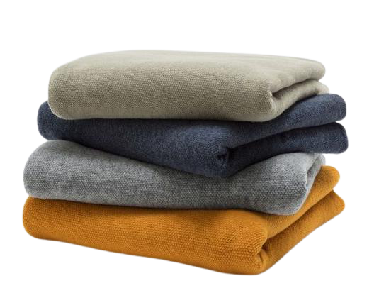 vier Decken übereinander in unterschiedlichen Farben. Beige, blau, grau, senfgelb