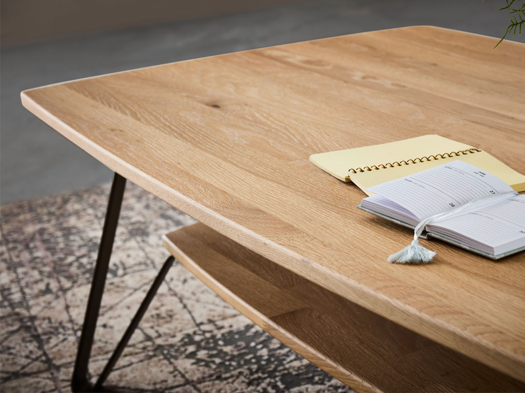 Detailaufnahme eines modernen Couchtisches aus Holz mit Metallgestell und einer Ablage stilvoll dekoriert in einem modernen Zimmer