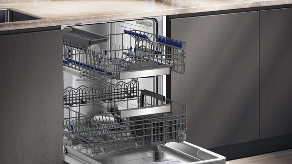 Offener Geschirrspüler mit zwei ausgefahrenen Körben, integriert in eine moderne Küchenzeile