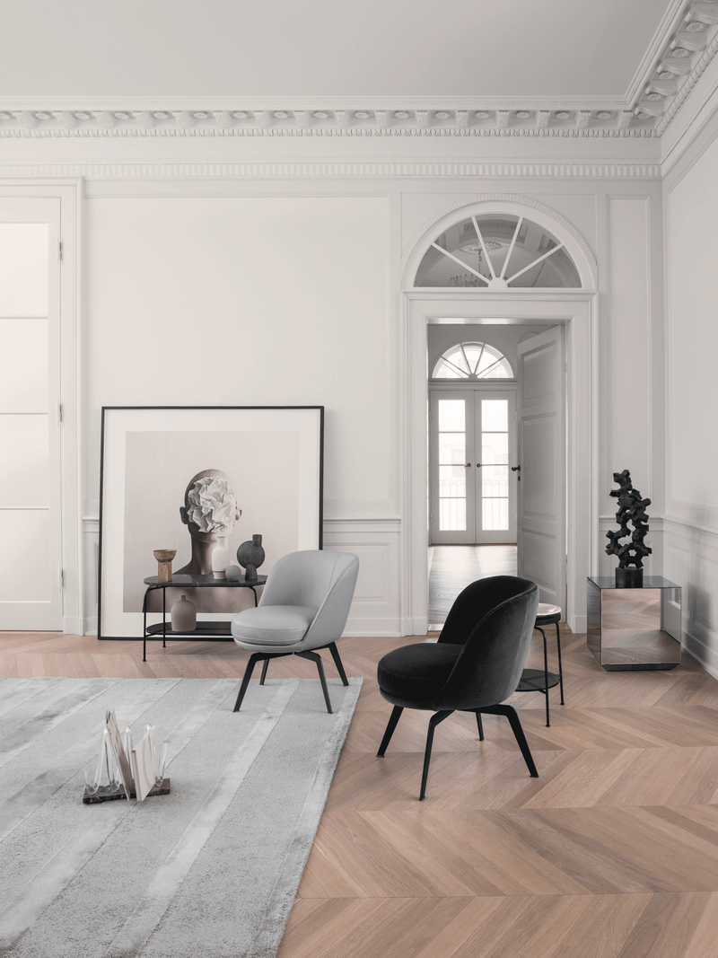 Wohnzimmer mit stilvollen Sesseln, einem großen Kunstwerk und dekorativem Teppich auf Holzboden