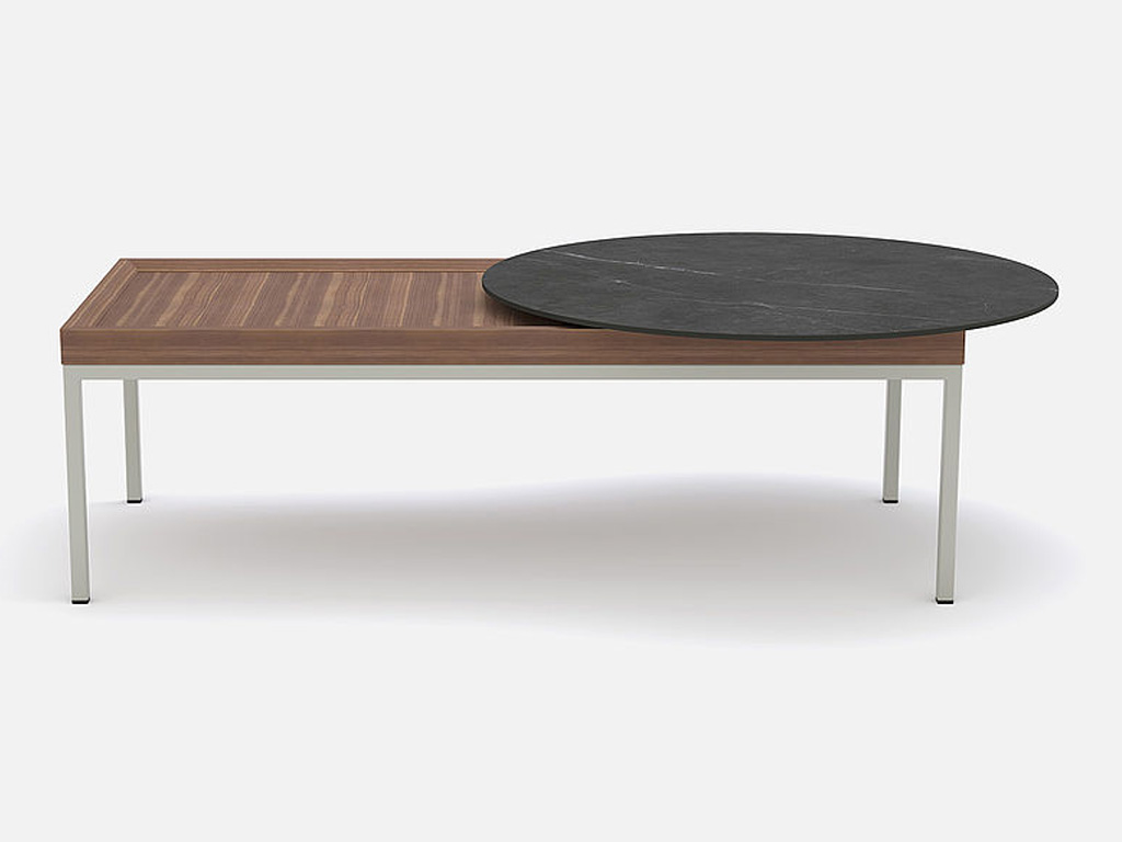 rechteckiger brauner Couchtisch mit hellem Gestell und einer runden schwarzen aufliegenden Platte vor grauem Hintergrund