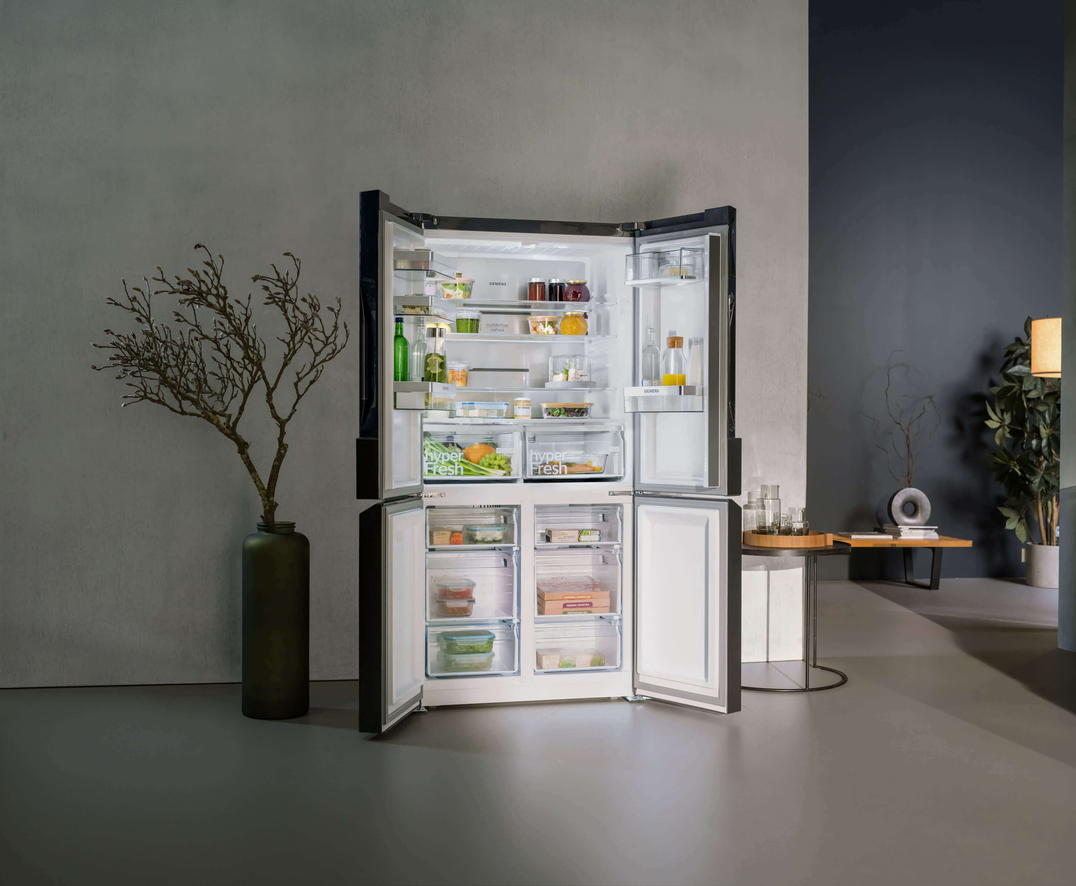Stylische Siemens Kühl-Gefrierkombination vor einer grauen Betonwand.