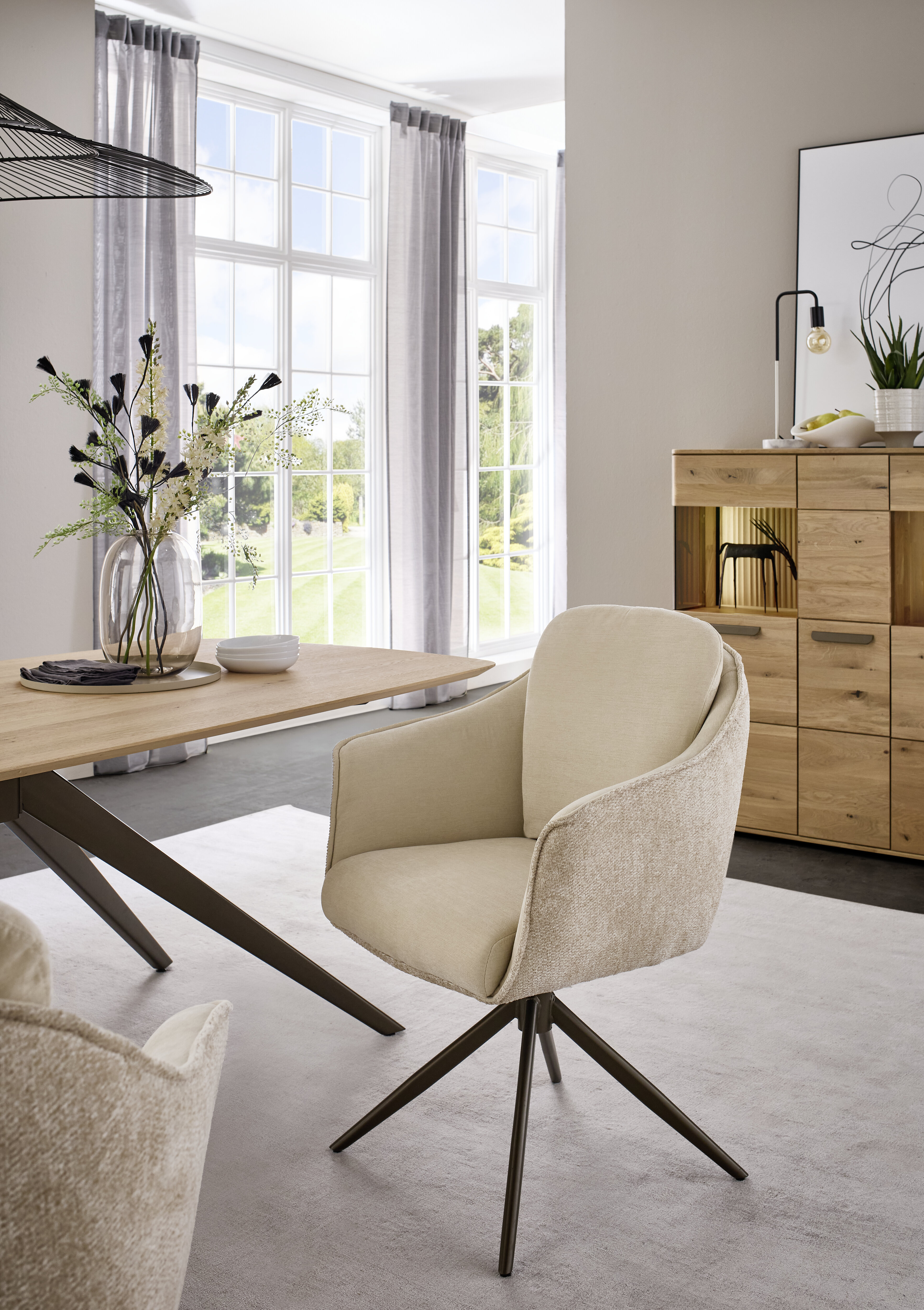 moderner Polsterstuhl in beige mit dunklem Metallgestell in einem modern hellen Esszimmer stilvoll dekoriert