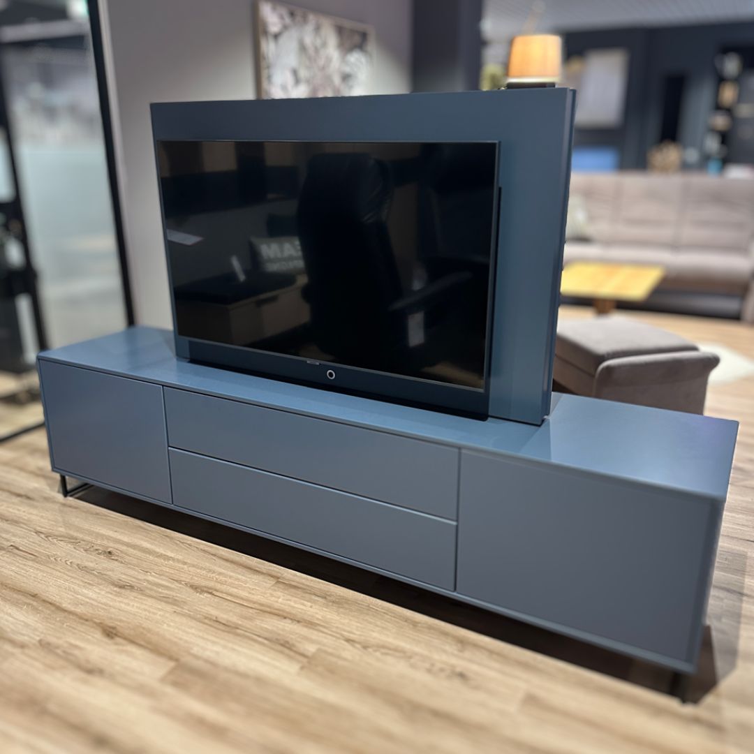 RMW. DEVISO | TV-Element Ein eleganter TV-Schrank in einem modernen Wohnzimmer, integriert mit einem Flachbildfernseher, umgeben von stilvoller Dekoration und Möbeln.