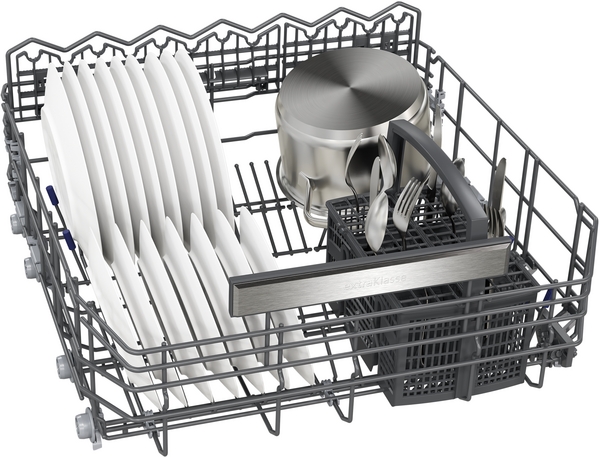 Ein Geschirrspülkorb voller Teller, Töpfe und Besteck, bereit zum Spülen in der Spülmaschine.