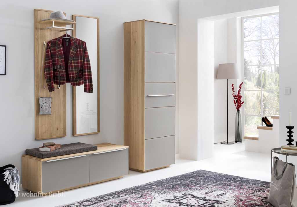 Bienenmühle Novum - Garderoben-Set, 4-teilig | Vorschlag 9 | Wildeiche furniert Ein eleganter Flur mit moderner Garderobe, bestehend aus einem hohen Schrank und einem Wandpaneel mit Spiegel, Mantel und Hut, kombiniert mit hellen Holzelementen.