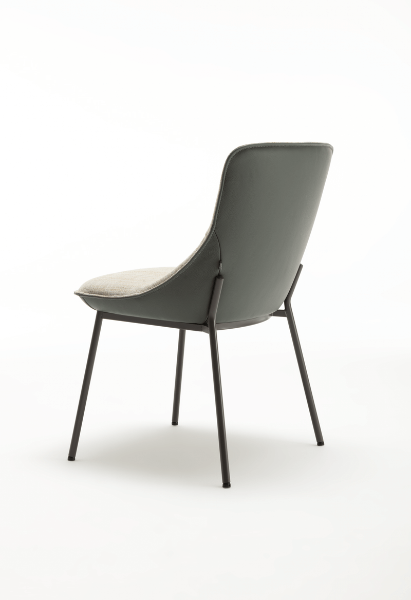 Rückansicht eines modernen Esszimmerstuhls mit gepolsterter grauer Rückenlehne und Metallbeinen