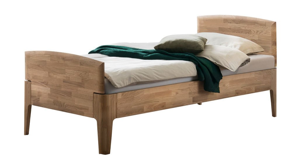 braunes Einzelbett mit Bettwäsche vor weißem Hintergrund