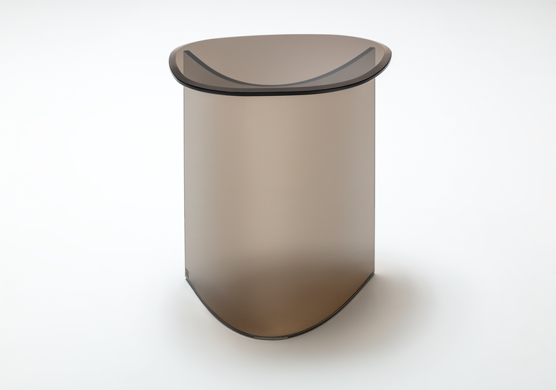 Ein moderner Couchtisch aus getöntem Glas mit eleganter, geschwungener Form auf weißem Hintergrund