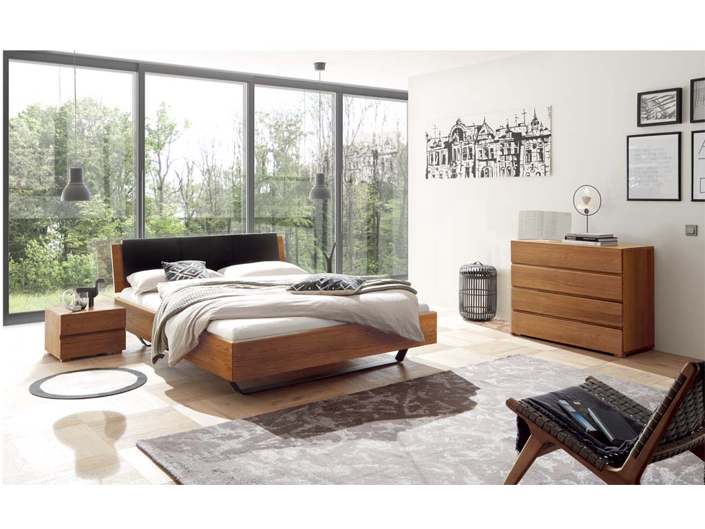 stilvoll eingerichtetes helles schlafzimmer mit holzmöbel darunter ein bett eine kommode ein nachtschrank diener von hasena