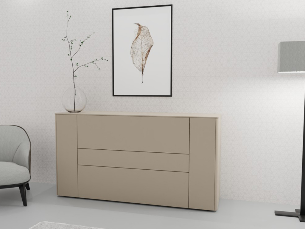 Sudbrock Goya - Sideboard | 2 Türen, 2 Schubladen, 1 Klappe | B: 175,2 cm | Lack terra Beigefarbene Kommode vor weißer Wand mit Pflanzenvase und Wandbild, daneben ein Sessel und eine Stehlampe.