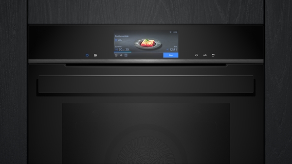 Einbaubackofen in dunkler Farbe mit einem digitalen Display, das ein Gericht und Kochinformationen anzeigt.