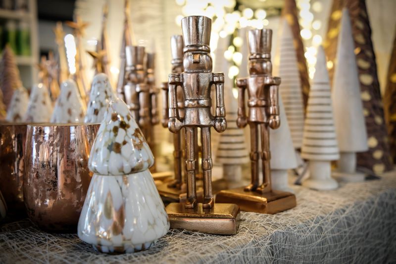 Eine Sammlung von kupfernen Nussknacker-Figuren und goldenen Weihnachtsbäumen als festliche Dekoration