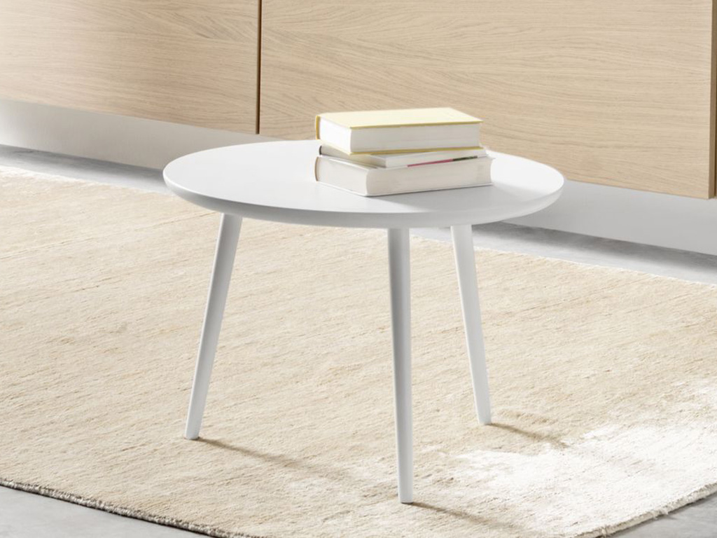 Sudbrock Mellini - Couchtisch rund Ø 55 cm | Massivholz oder Lackausführung | Höhe 39 oder 49 cm Kleiner, runder weißer Couchtisch mit drei Beinen und Bücherstapel darauf, platziert auf einem beigefarbenen Teppich in einem modernen Wohnzimmer.