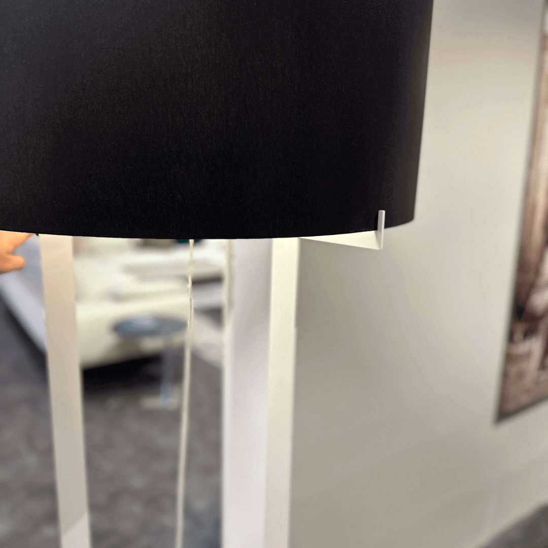 Detailansicht einer modernen Stehlampe mit schwarzem Lampenschirm in einem Wohnzimmer
