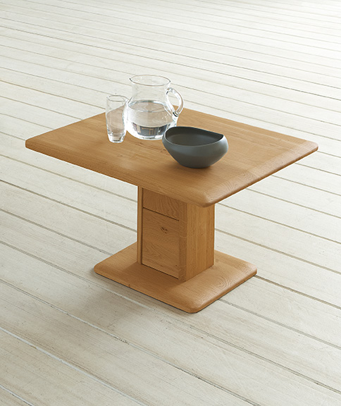 Moderner Beistelltisch aus hellem Holz mit Glas und Schale darauf, auf hellem Holzboden stehend