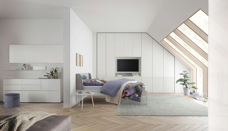 Schlafzimmer mit weißen Möbeln, eingepasstem Schrank in der Dachschräge und Sideboard passend zum Kleiderschrank