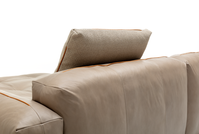 Nahaufnahme eines beigen Sofas aus Leder mit verstellbarem Kopfkissen in neutralen Tönen