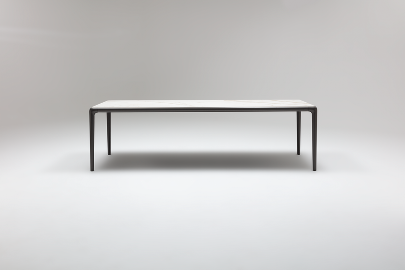 Minimalistischer Esstisch mit schwarzem Metallrahmen und heller Tischplatte in leerem Raum