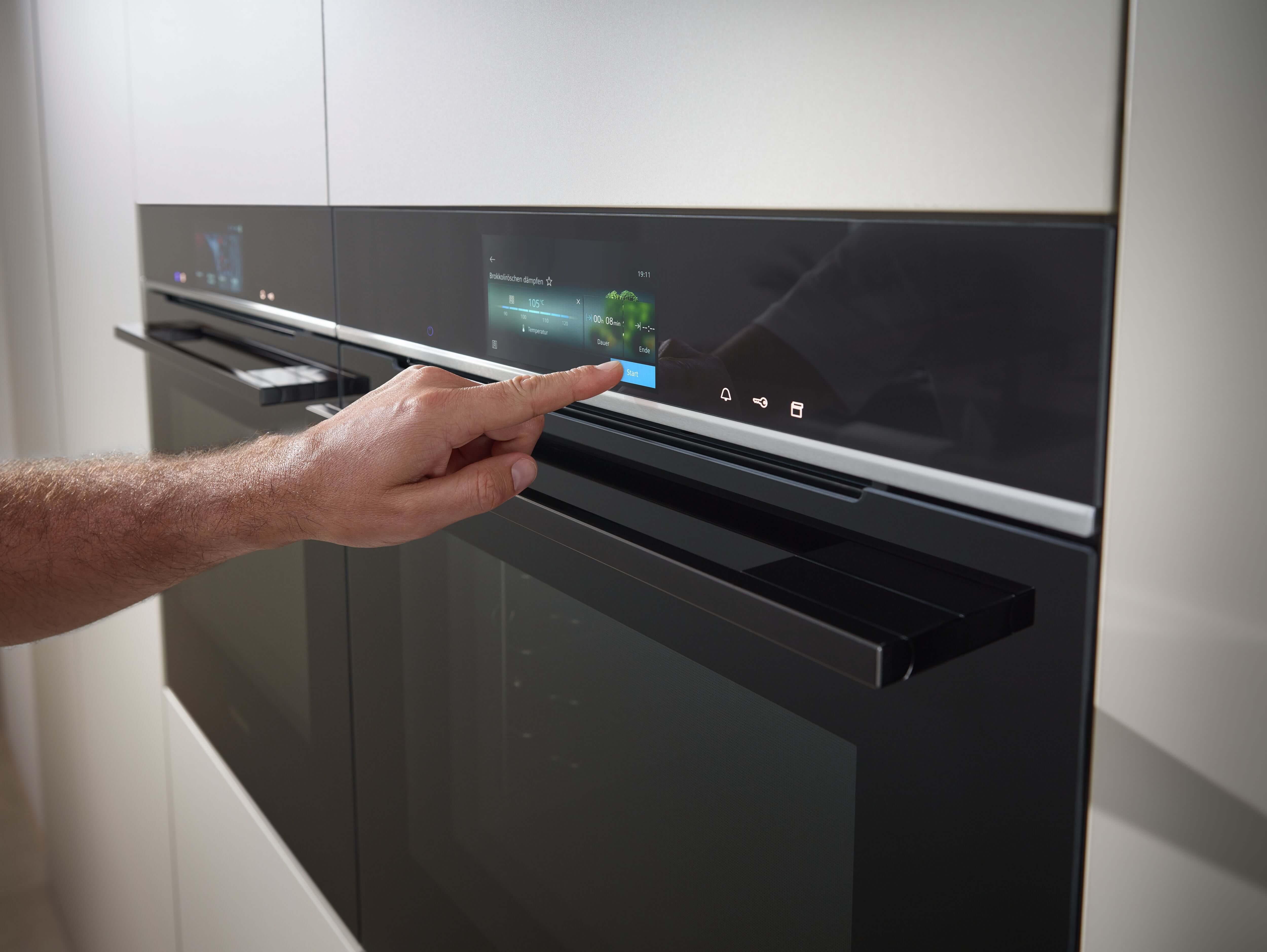 Person wählt auf einem Siemens powerLine Backofen das gewünshte Programm für die Zubreitung seines Gerichtes aus.