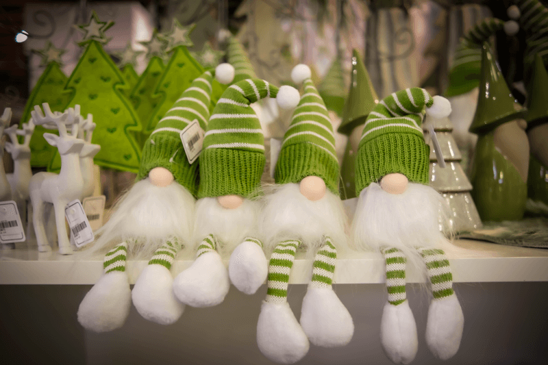 grüne Weihnachtswichtel auf einer Tischkante sitzend