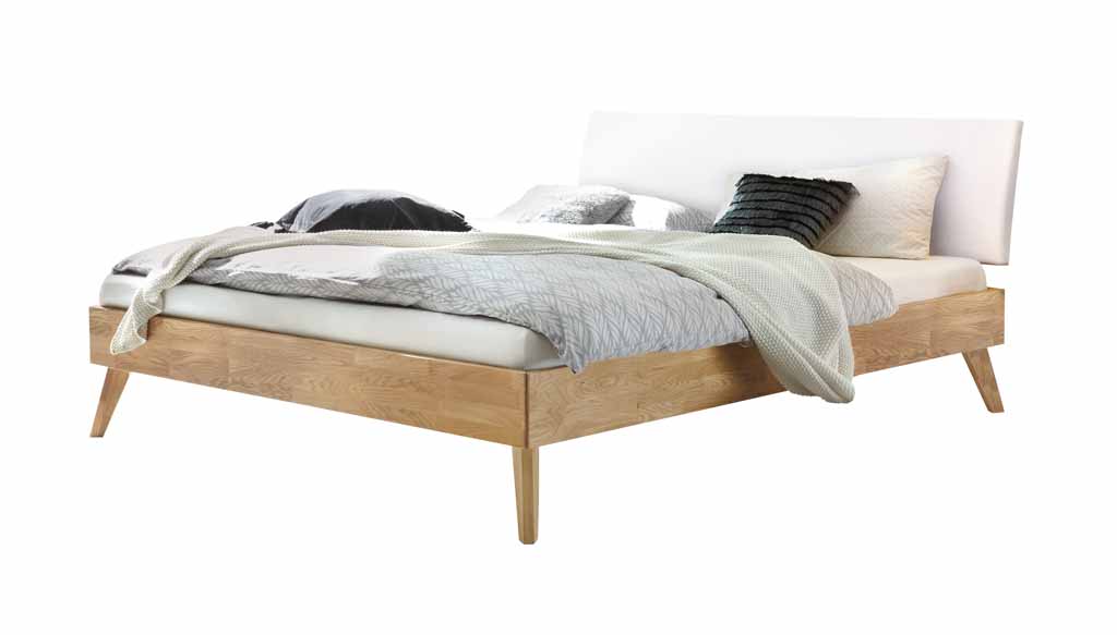 Hasena Trento - Bett Pesaro | Eiche bianco, geölt | Kopfteil Kunstleder weiß Schönes Holzbett mit weißem Kopfteil, ausgestattet mit Kissen und Decken
