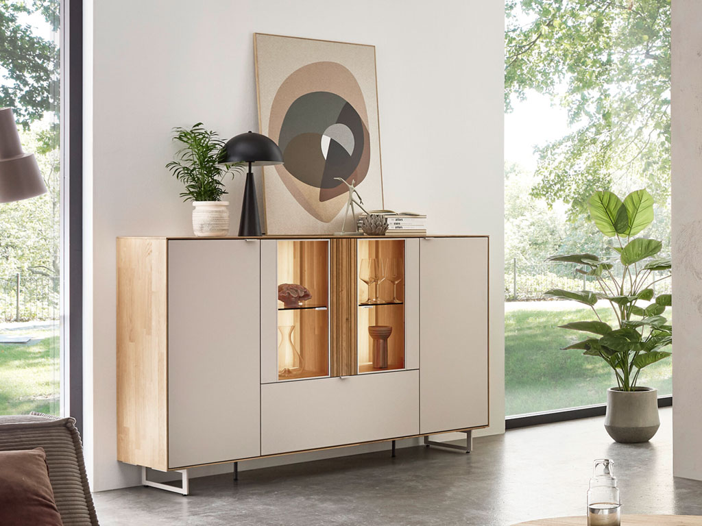 modernes Highboard mit Vitrinenausschnitt und Beleuchtung in braun-weiß stilvoll dekoriert in einem hellen Raum