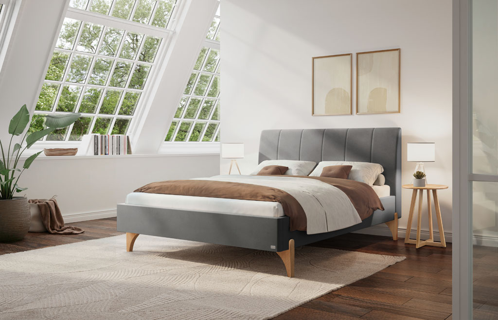 Graues Polsterbett mit vertikal gestepptem Kopfteil und hellen Holzfüßen in einem modernen Schlafzimmer mit Dachfenster (KI-generiert)