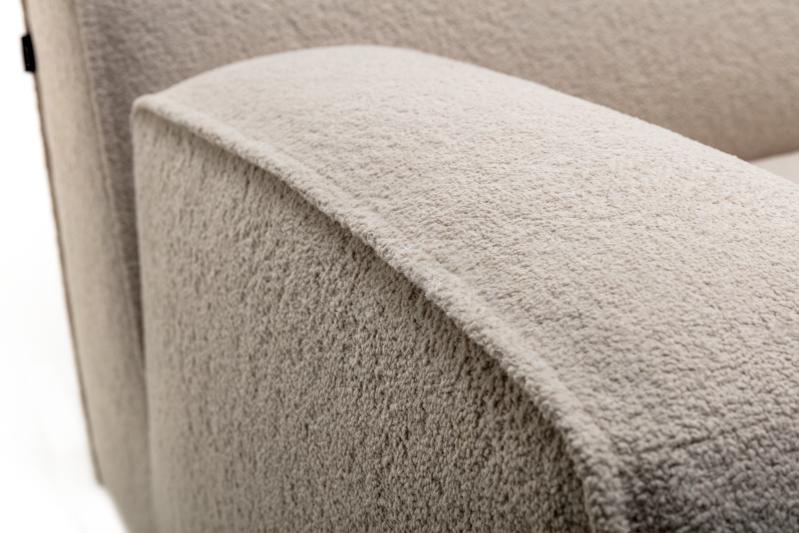Detailaufnahme eines beigen Sofas vor weißem Hintergrund