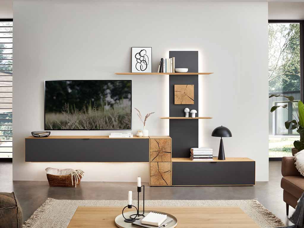 Wöstmann WM 2410 - Wohnwand | Type 0004/0104 | Lack und Wildeiche massiv | Hirnholzakzent Modernes Wohnzimmer mit stilvollem Regal, Fernseher und Dekorationen wie Bücher und Lampen auf hellgrauer Wand