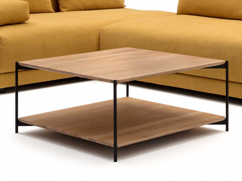 Moderner Couchtisch aus hellem Holz mit schwarzem Metallgestell vor einem gelben Sofa
