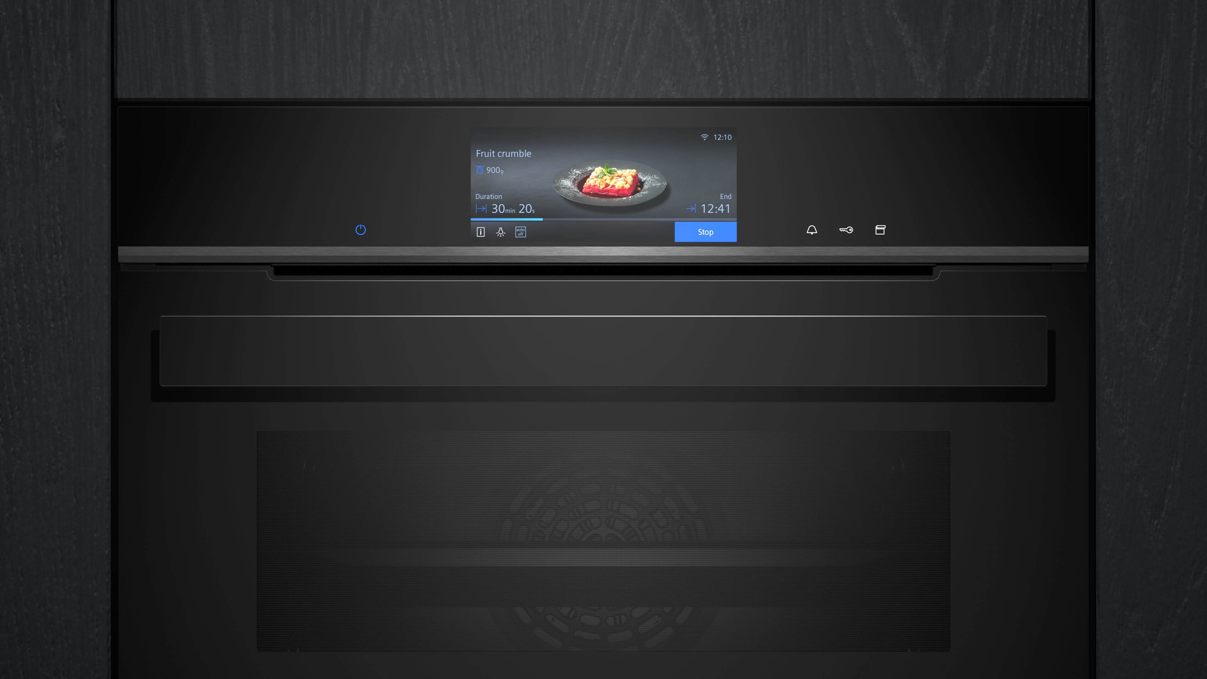 Nahaufnahme der Bedienblende und des digitalen Touch-Displays des Siemens-Backofens, auf dem die Zubereitung von „Fruit crumble“ angezeigt wird.
