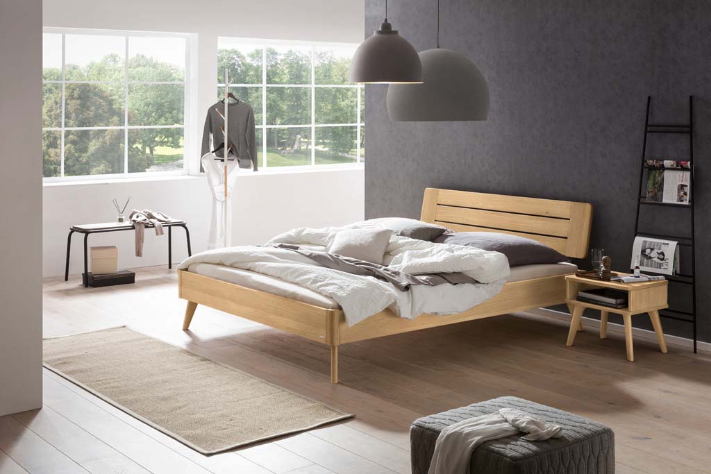 Holzbett mit Holznachttisch in einem stilvoll eingerichten Zimmer