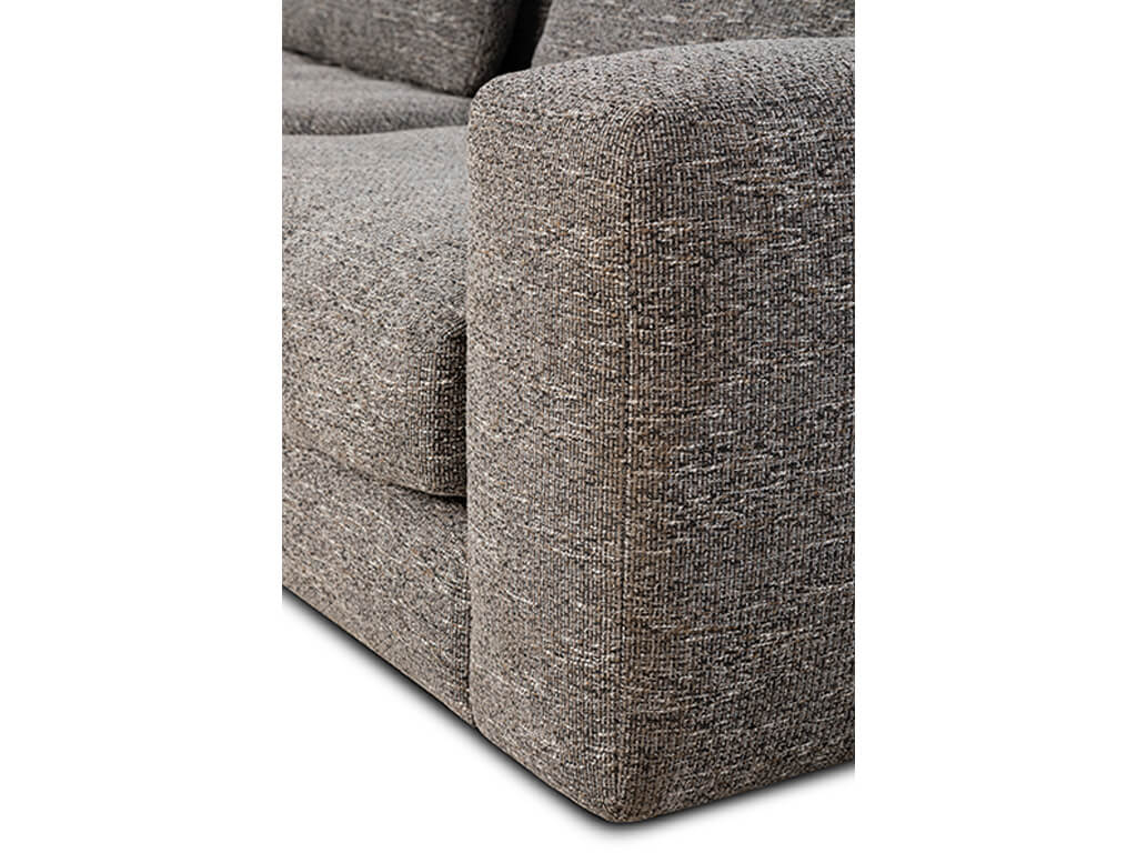 Nahaufnahme der Ecke eines beigen Stoffsofas mit strukturierter Oberfläche, die die Armlehne und den Seitenbereich zeigt.