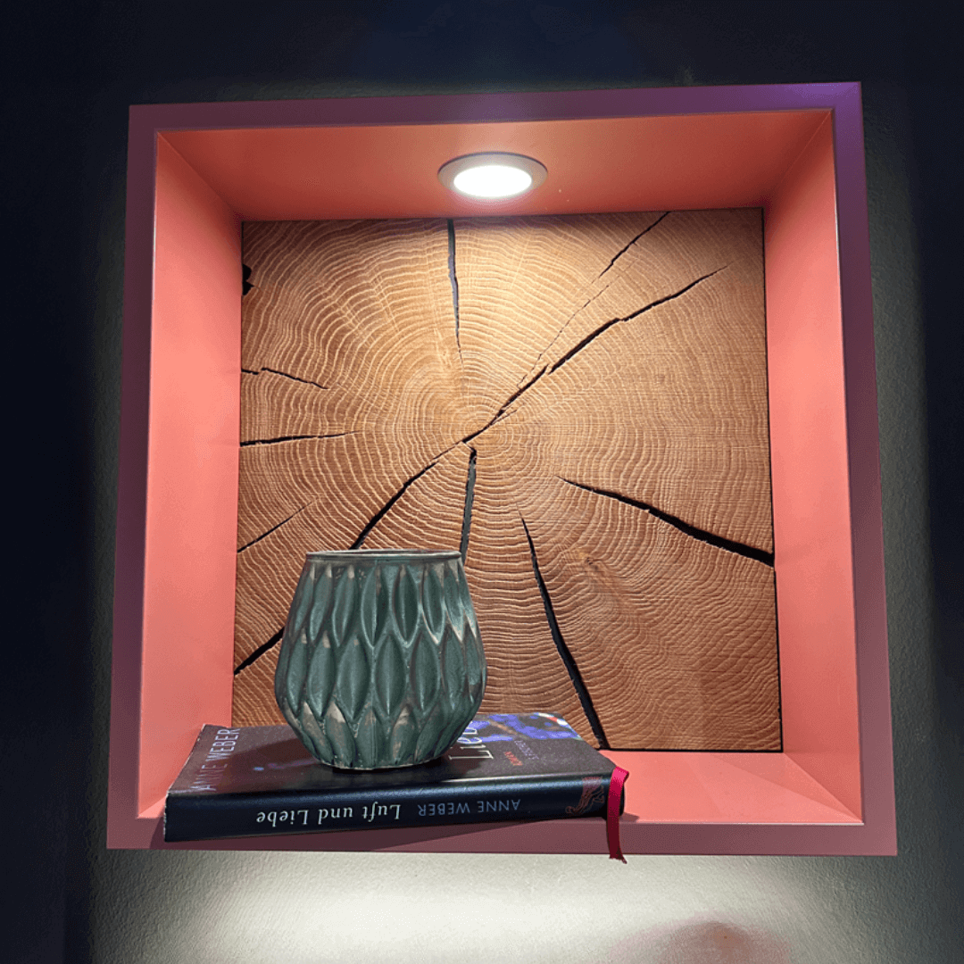 RMW DEVISO | Wandregal Rosa Wandnische mit Holzrückwand, beleuchtet von einer LED-Lampe, darin eine Vase und ein Buch platziert