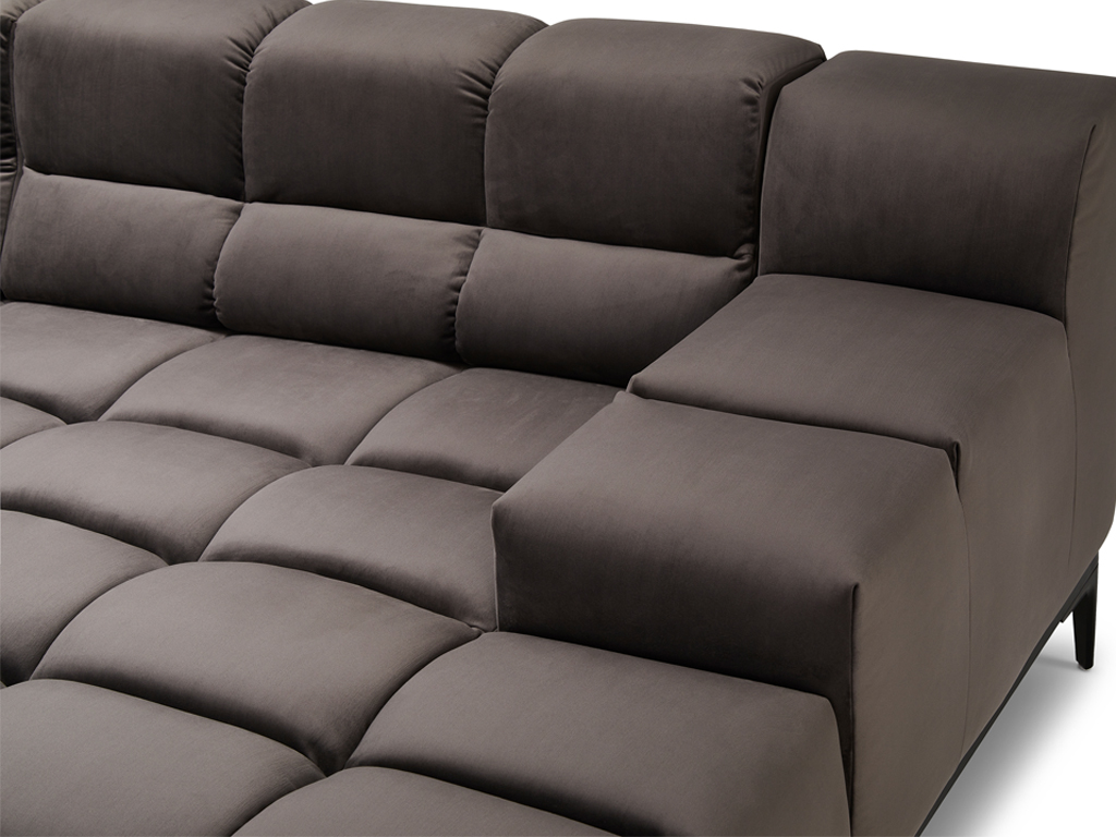 Nahaufnahme des dunkelgrauen Sofas, die den Übergang von einem Sitzmodul zu einer Armlehne oder einem höheren Rückenelement zeigt. Die gesteppte Struktur ist deutlich sichtbar.