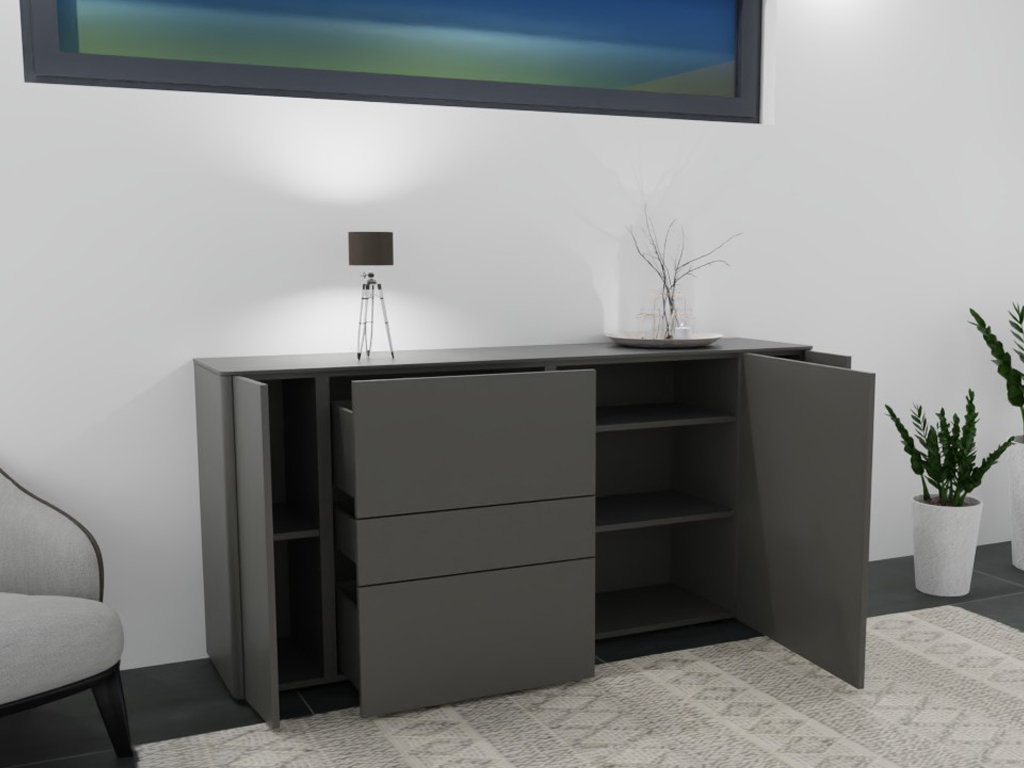 Graue Kommode mit geöffneter Tür und Schubladen, dekoriert mit Lampe und Vase, neben einem Sessel und Pflanzen