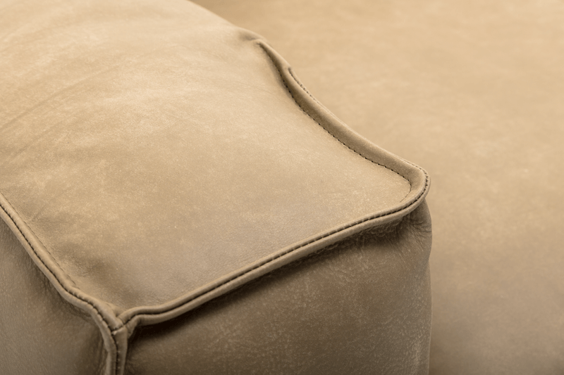 Detailansicht einer beigen Ledercouch mit Fokus auf die Naht