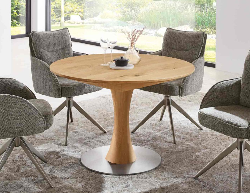 runder Holzesstisch mit silbernem Standfuß und vier Polsterstühlen in grau in einem modernen  Zimmer