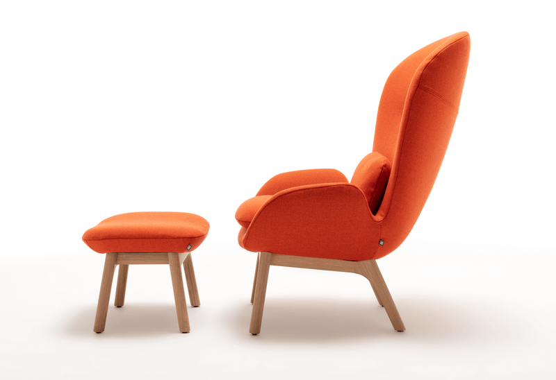 Moderner Lounge-Sessel in Orange mit passendem Hocker aus Holz. Bequemes Design für stilvolle Wohnräume.
